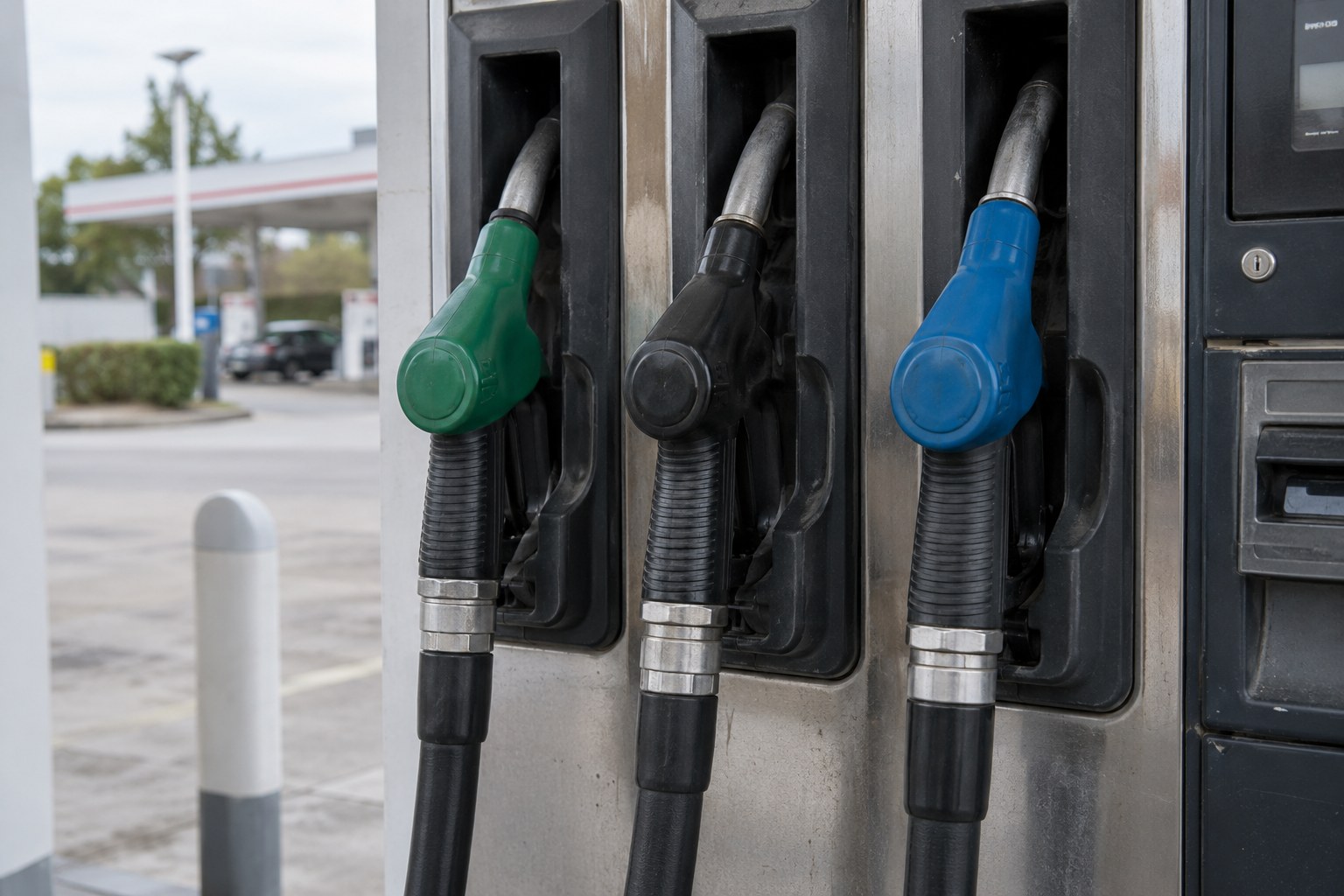 Zapfpistolen hängen an einer Tankstelle.