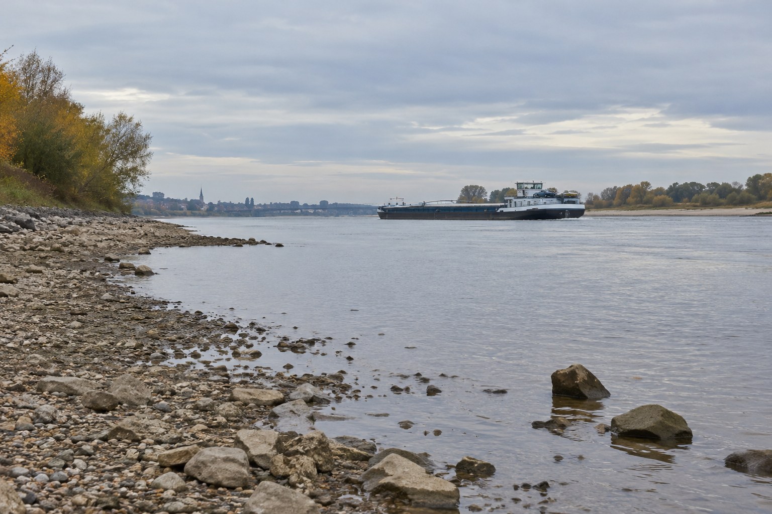 Frachtschiff auf einem Fluss mit niedrigem Wasserstand.