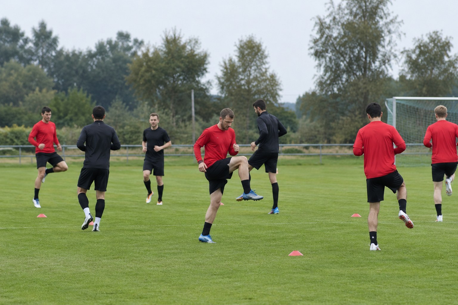 Fußballspieler beim Aufwärmen auf einem Trainingsfeld.