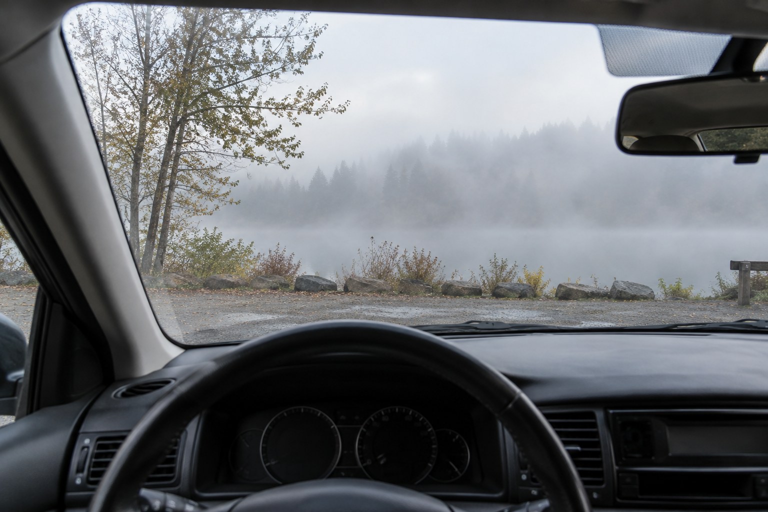 Nebel vor der Windschutzscheibe eines abgestellten Autos.