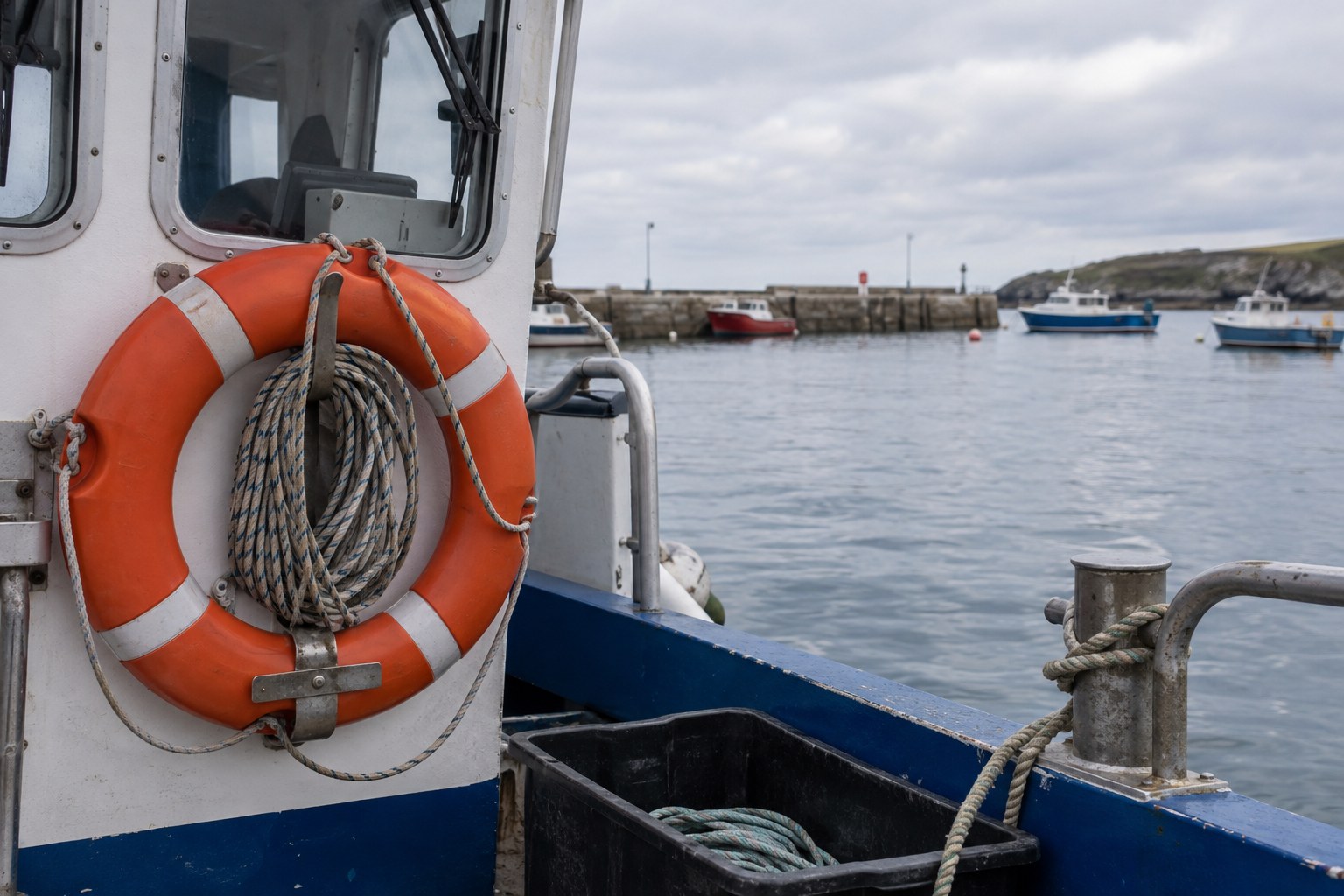 Rettungsring und Leinen an einem im Hafen liegenden Boot.