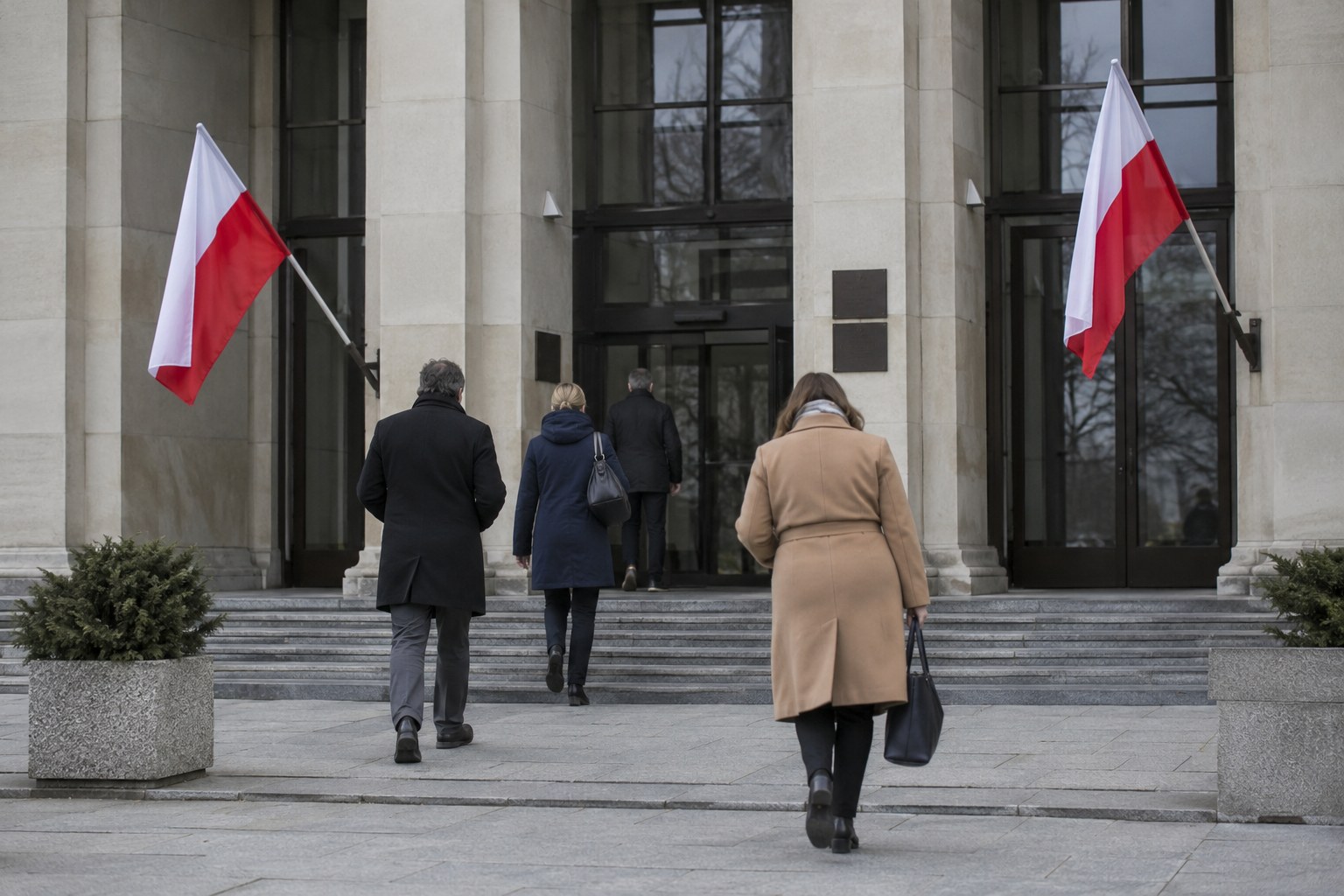 Polnische Flaggen vor einem öffentlichen Eingang.