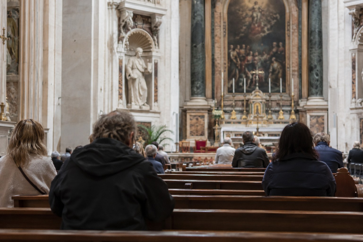 Besucher sitzen in einer Kirche.