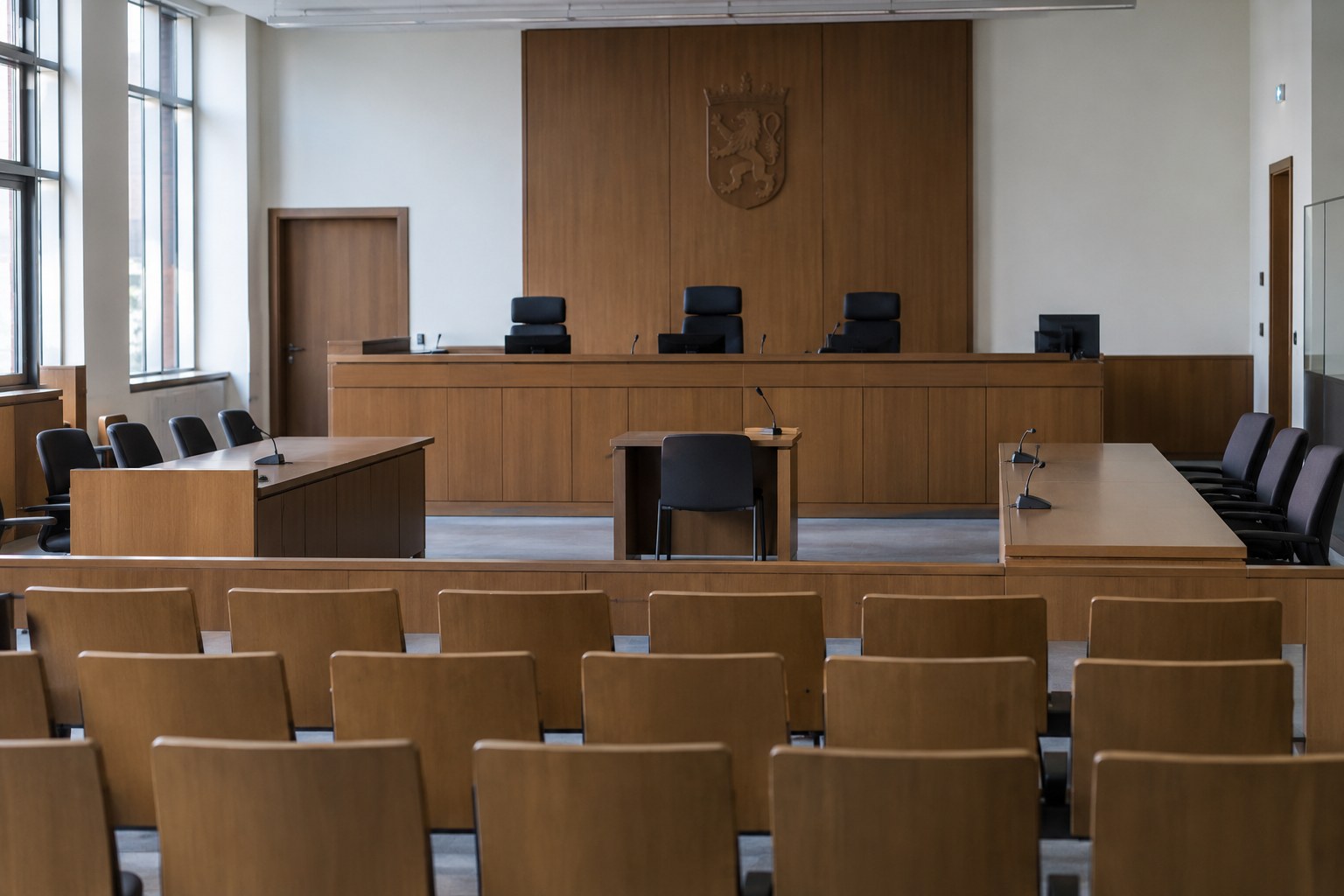 Ein leerer Gerichtssaal mit Richterbank und Sitzreihen.