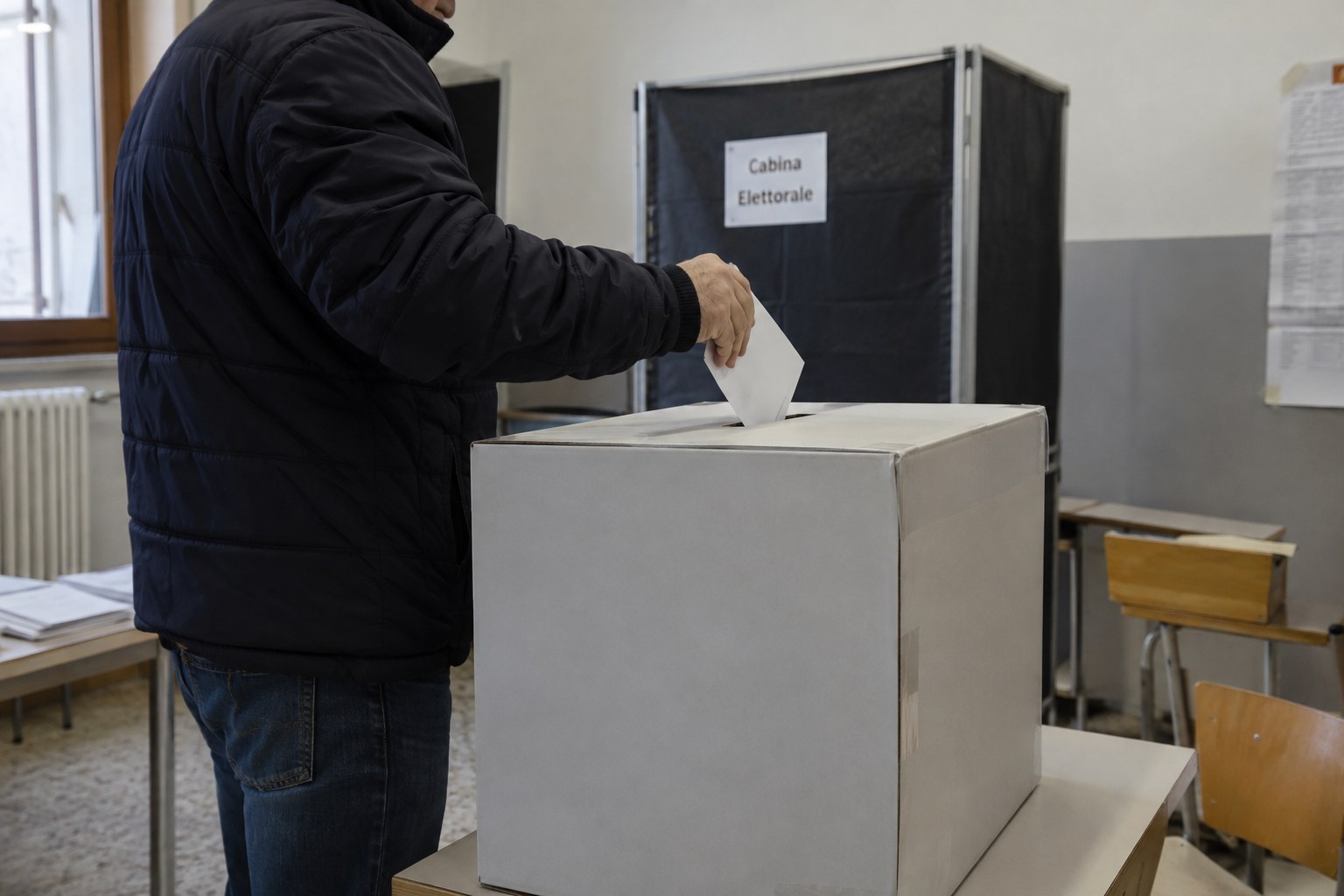 Eine Wählerin wirft einen Stimmzettel in eine Wahlurne.
