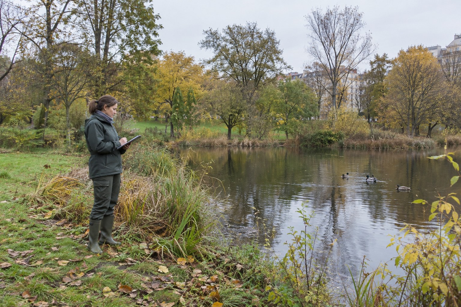 Eine Naturschutzmitarbeiterin hält Beobachtungen an einem Teich fest.