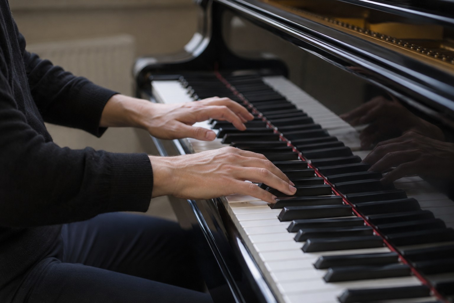 Hände spielen auf der Tastatur eines Flügels.
