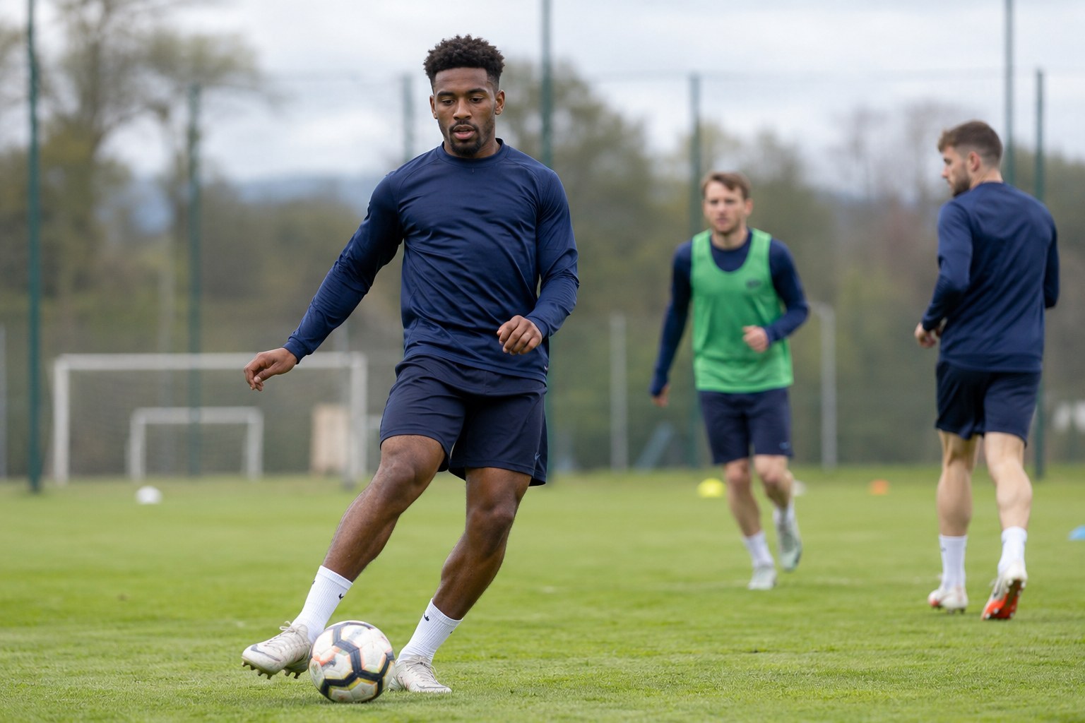 Ein Fußballspieler trainiert auf einem Rasenplatz.
