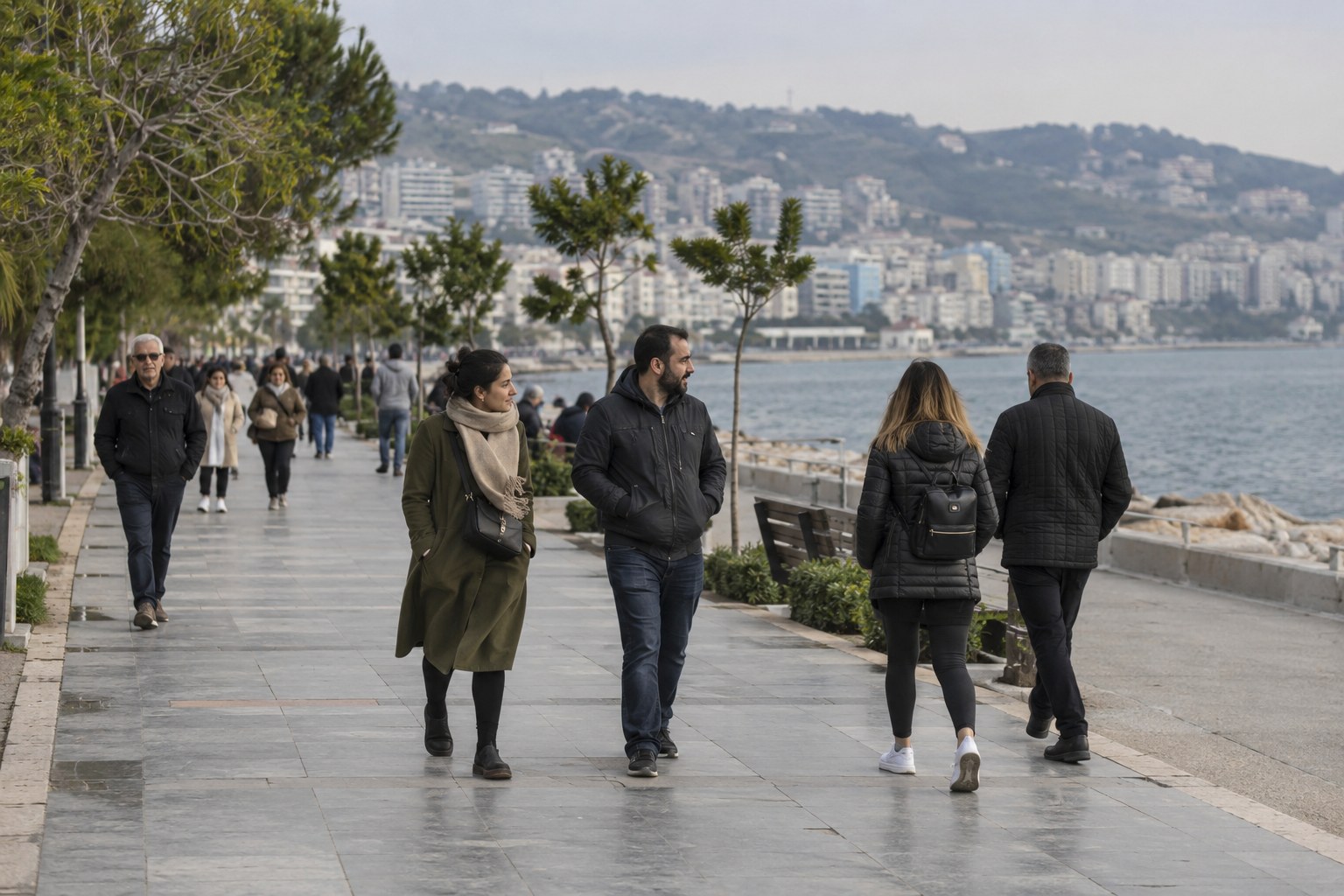 Menschen spazieren an einer türkischen Küstenpromenade.