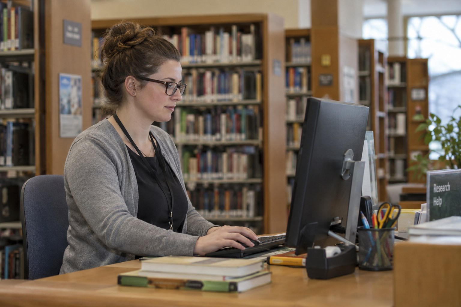 Eine Person nutzt einen Computer in einer Bibliothek.