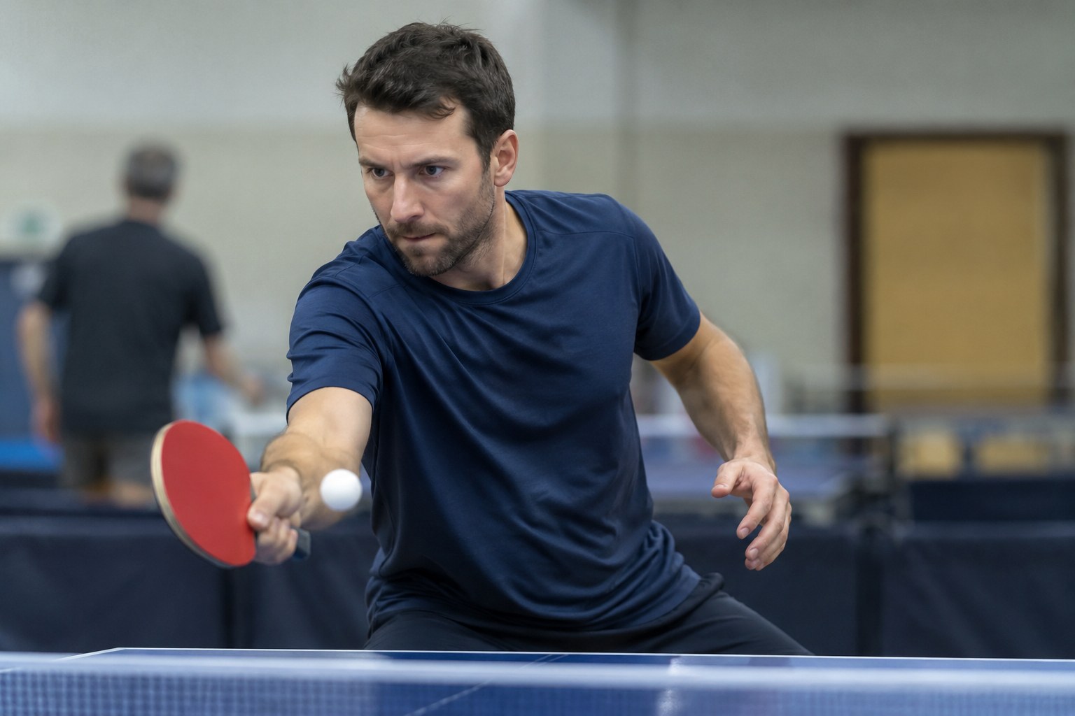 Ein Tischtennisspieler schlägt einen Ball.