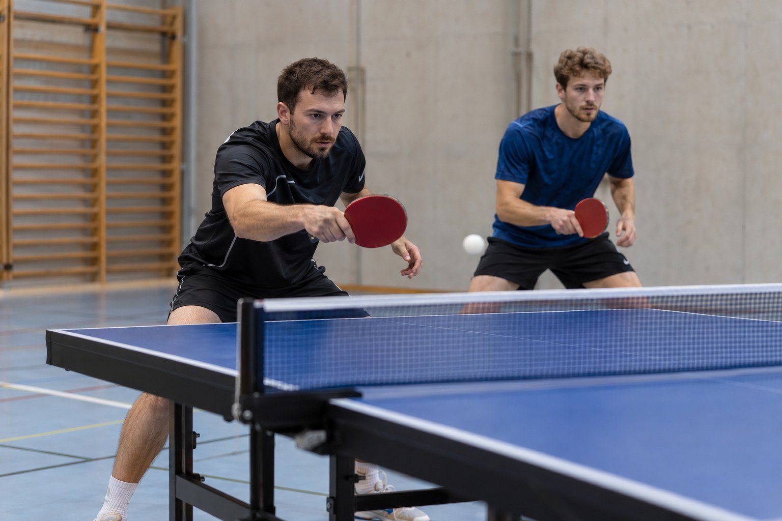 Vier Spieler beim Tischtennis-Doppeltraining.